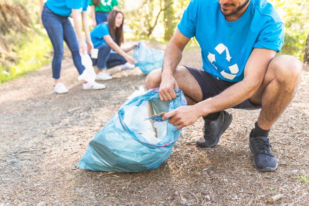 Voluntarios recogiendo basura en el bosque.