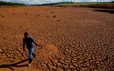 Hombre caminando sobre un terreno agrietado y seco por la sequía en Colombia.